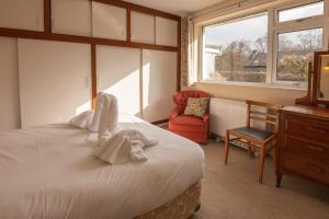 a bedroom with a bed and a chair and a window at Beckfoot Chapel Stile - Ambleside in Chapel Stile