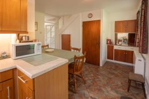 a kitchen with a microwave and a table with chairs at Beckfoot Chapel Stile - Ambleside in Chapel Stile