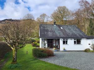 a white house with a tree in the yard at Beckfoot Chapel Stile - Ambleside in Chapel Stile