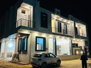 KhātuHotel Raj Krishanam的晚上停在建筑物前的汽车