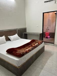 a bedroom with a bed and a bathroom with a shower at Hotel Raj Krishanam in Khātu