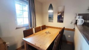 una mesa de madera en una habitación con cocina en Argousiers 105 en Fort-Mahon-Plage