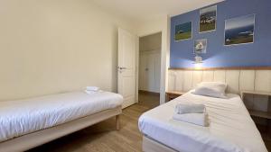 2 camas en una habitación con paredes azules en Argousiers 105 en Fort-Mahon-Plage