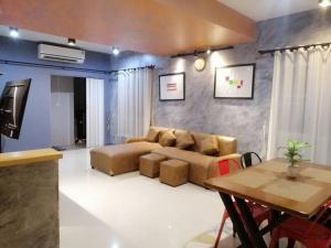 a living room with a couch and a table at The Lake Guest House in Ban Bang Phang