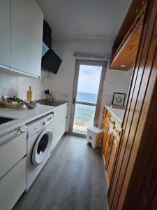 een keuken met een wasmachine en uitzicht op de oceaan bij Apartamento Sara in Santa Cruz de Tenerife