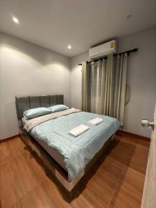 una camera da letto con un letto e due asciugamani di The Lake Guest House a Ban Bang Phang