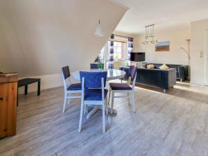 a dining room and living room with a table and chairs at Dörte in Greetsiel