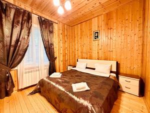 a bedroom with a bed in a wooden room at Deluxe Park Qusar Resort & Spa Hotel in Qusar