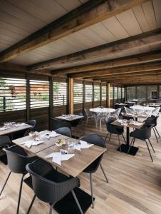 a dining room with tables and chairs in a room at What Else Hotel in Saint-Vulbas