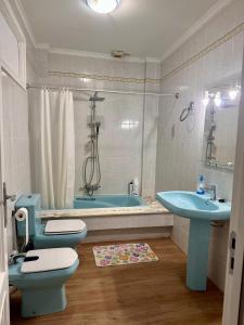 uma casa de banho com um WC azul e um lavatório. em Apartamento Tranquilo Zona Paseo de Lordelo - WIFI em O Grove