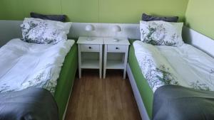 Dos camas en una habitación con mesita de noche. en Fornilækur Guesthouse, en Blönduós