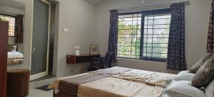 a bedroom with a bed and a window at Sugamya Farm Guesthouse in Sāgar