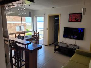 ein Wohnzimmer mit einem Sofa, einem Tisch und einem TV in der Unterkunft APARTAMENTO 1 DORMITORIO EN PUNTA DEL ESTE in Punta del Este