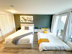 2 Betten in einem Zimmer mit grünen Wänden und Fenstern in der Unterkunft Studio LIV204 by Gestion ELITE in Mont-Tremblant