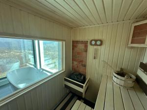 a small bathroom with a tub and a window at Hovk Farms in Dilijan