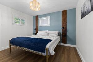 een slaapkamer met een bed met een blauwe muur bij Duplex on the Bluff in Caseyville