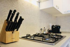 a knife block next to a stove in a kitchen at [Fronte lago]ResidenceGarden, moderno appartamento in Calceranica al Lago