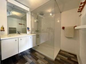 a white bathroom with a shower and a sink at Maison Les Agapanthes in Lanmodez
