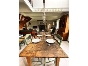 a long wooden table in a room with chairs at Maison Les Agapanthes. in Lanmodez
