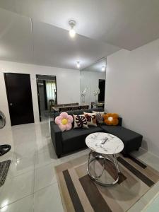een woonkamer met een zwarte bank en een tafel bij Casa Moanna 2BR-3beds spacious Dining, kitchen,Living Area, Wifi in Mandaue-stad