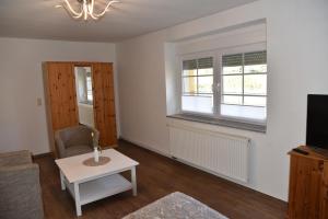 sala de estar con TV y mesa en Ferienwohnung am Netzener See en Lehnin