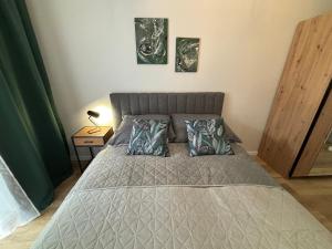 a bedroom with a bed with two pillows on it at Apartamenty POSNANIA - MALTA , Faktura VAT, bezkontaktowe zameldowanie, bezpłatne miejsce parkingowe in Poznań