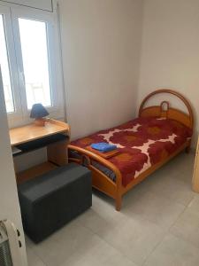een kleine slaapkamer met een bed en een bureau bij Barcelona Terrassa in Terrassa