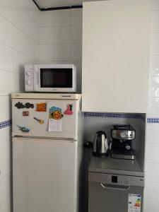 een magnetron bovenop een koelkast in een keuken bij Barcelona Terrassa in Terrassa