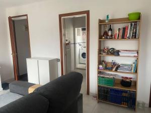 een woonkamer met een bank en een boekenplank bij Barcelona Terrassa in Terrassa