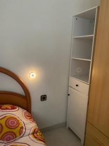 een kleine slaapkamer met een bed en een witte kast bij Barcelona Terrassa in Terrassa