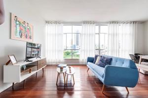 a living room with a blue couch and a table at Amplo apartamento Barra Salvador in Salvador