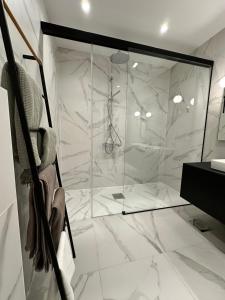 a bathroom with a shower with white marble tiles at Ambassador Tallinn in Tallinn +18 photos