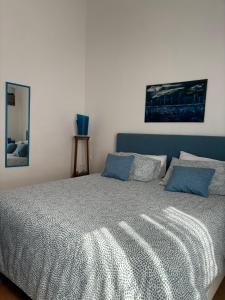 a bedroom with a large bed with blue pillows at Casa Vacanze Penelope in Trapani