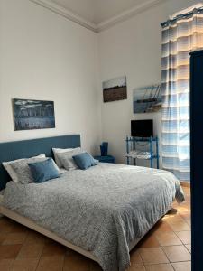 a bedroom with a large bed with blue pillows at Casa Vacanze Penelope in Trapani