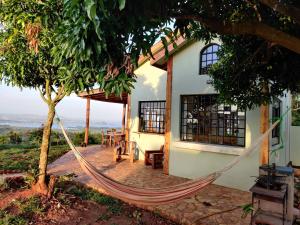 a hammock in front of a house with a view at Harry's Cabin - Overlooking Lake Victoria - 30 min from Jinja in Jinja