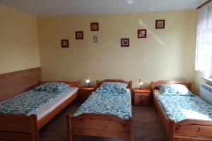 2 Betten in einem Zimmer mit Kerzen an der Wand in der Unterkunft Mała Chatka in Krzeszów