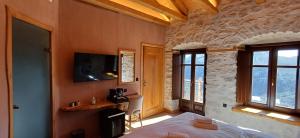 a bedroom with a bed in a room with windows at Casagli Luxury Suites in Dimitsana