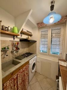 a kitchen with a stove and a washing machine at TrentapassidalMare Quinto al mare in Genova