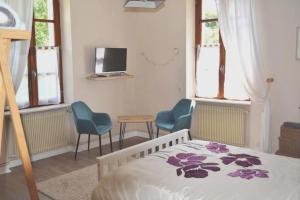 um quarto com uma cama e duas cadeiras e uma televisão em Les Bruyeres B&B em Montbron