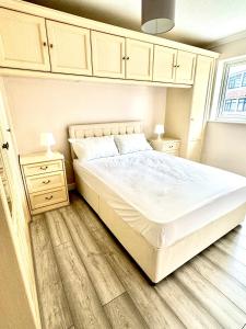 a bedroom with a large bed and a wooden floor at StayViva - Spacoius 3 BR House - Garden, Games Room, Parking near Town Centre and Train station in Bracknell
