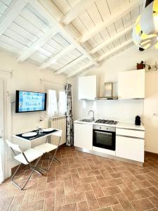 - une cuisine avec des placards blancs et une cuisinière dans l'établissement Appartamento Cà Insulae, à Luni