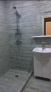 y baño con ducha y lavamanos. en Уютен нов апартамент - Стара Загора en Stara Zagora