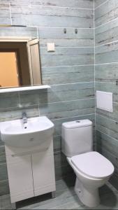 a bathroom with a toilet and a sink and a mirror at Уютен нов апартамент - Стара Загора in Stara Zagora