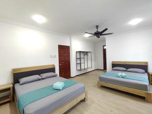 - une chambre avec 2 lits et un ventilateur de plafond dans l'établissement Tar1 @ ONE Homestay, 4 Bedroom, à Sibu
