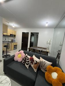 a living room with a black couch with colorful pillows at Casa Moanna 2BR Condo with Dining, kitchen, Living Area and Netflix in Mandaue City +15 photos