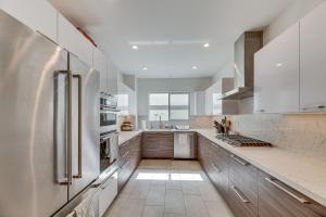 uma cozinha com electrodomésticos brancos e uma grande janela em WFH-Friendly Condo in LA 2 Mi to Santa Monica! em Los Angeles
