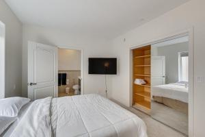 um quarto branco com uma cama e uma televisão em WFH-Friendly Condo in LA 2 Mi to Santa Monica! em Los Angeles