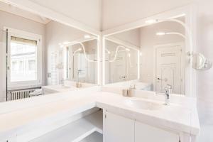 a white bathroom with two sinks and a large mirror at Appartamento di lusso con terrazza sull'acqua in Venice +59 photos