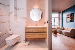 een badkamer met een wastafel, een toilet en een spiegel bij Hotel Keur in Zandvoort
