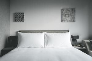 een slaapkamer met een wit bed met twee foto's aan de muur bij SAPPORO STREAM HOTEL in Sapporo
